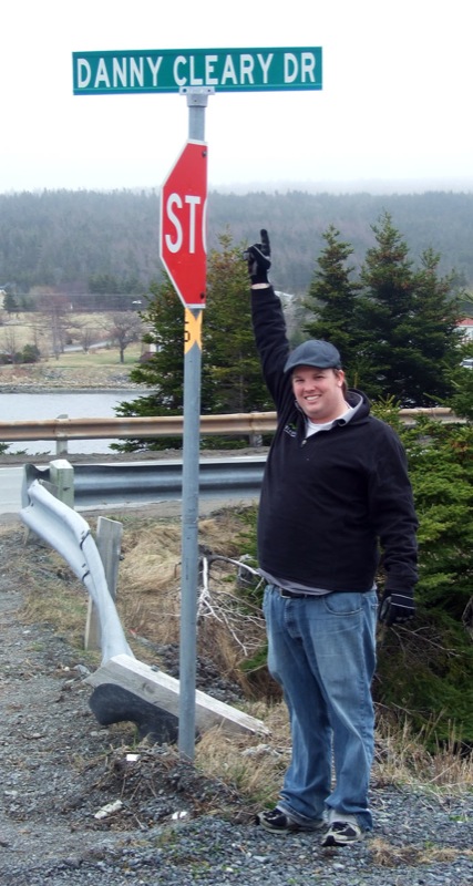 a man stands next to a road sign