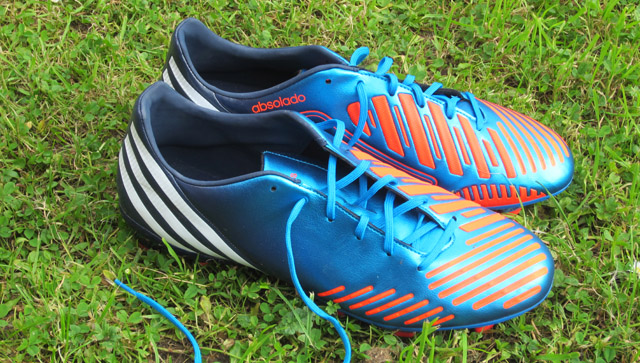 an overhead view of a pair of soccer boots on grass