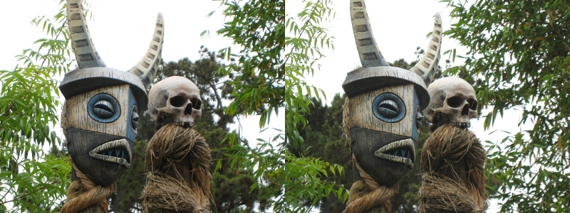 two masks are on display in a tree
