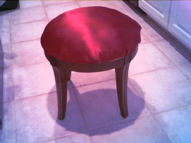 a small red stool with a leather seat