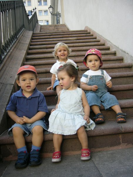 five children sit on stairs in a row
