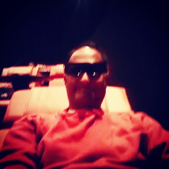 an asian man in shades relaxing in a theater