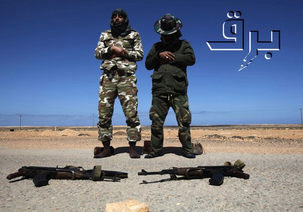 two soldiers with weapons sitting in the desert