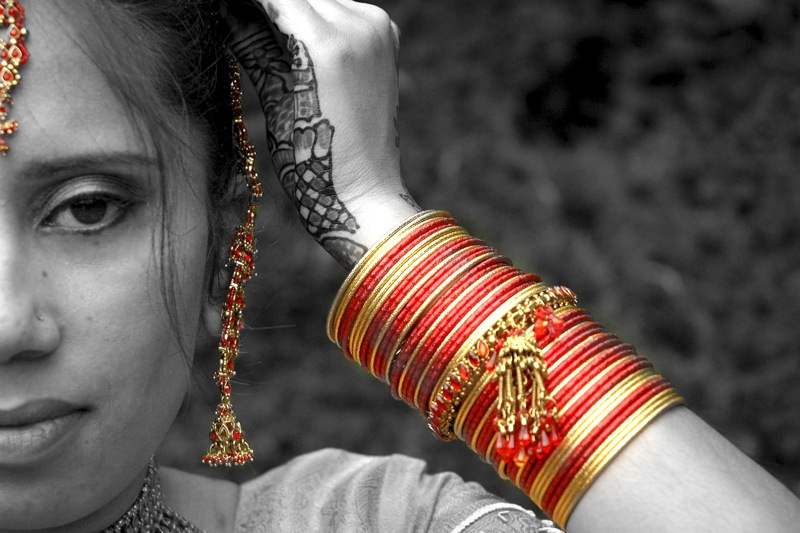 black and white pograph of a woman wearing some red and yellow celets