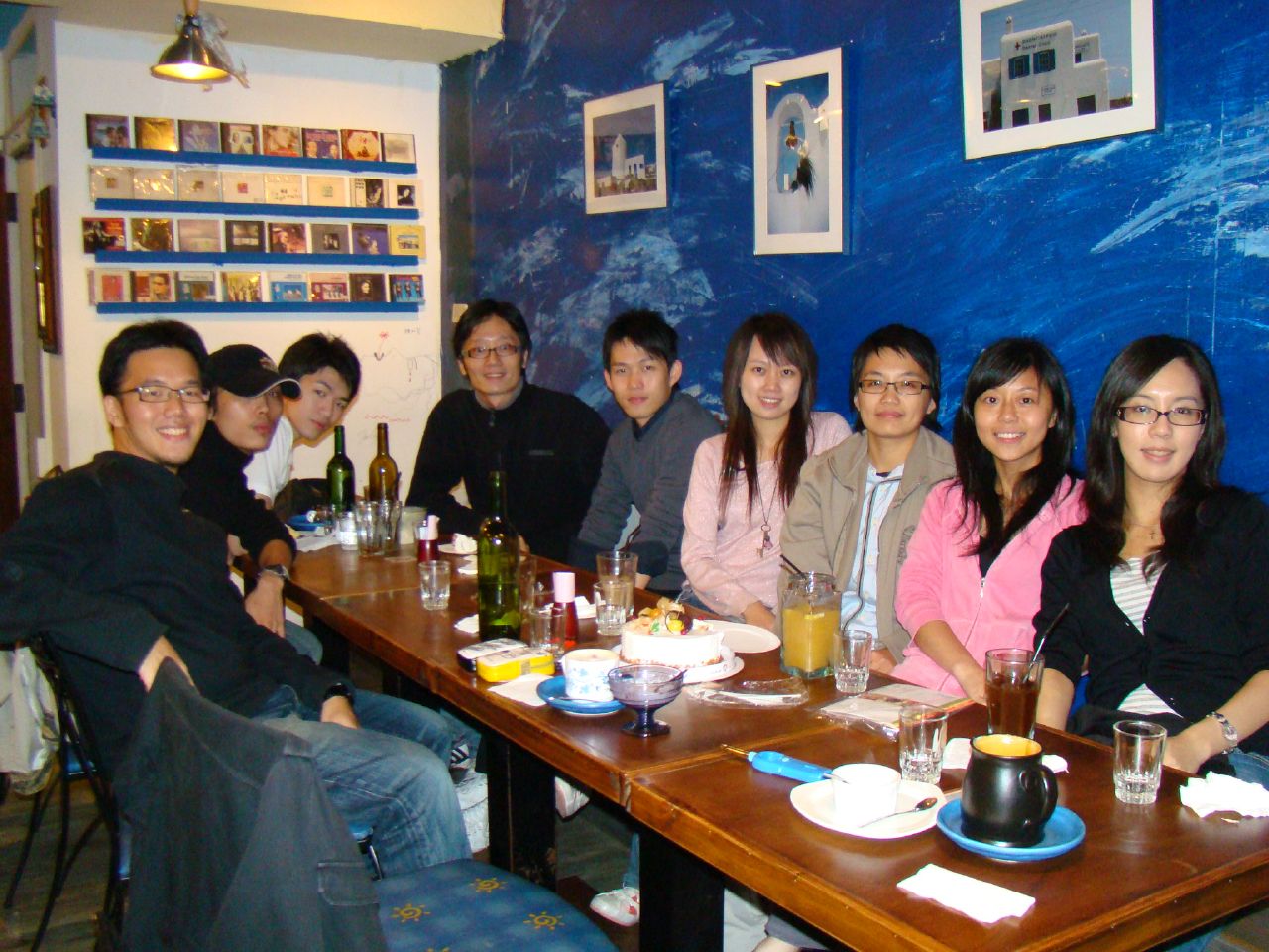 a group of people seated at a wooden table posing for the camera