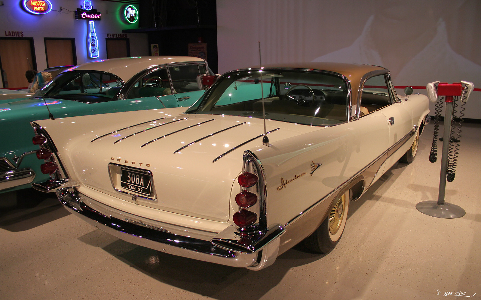 a vintage car on display with other classic cars