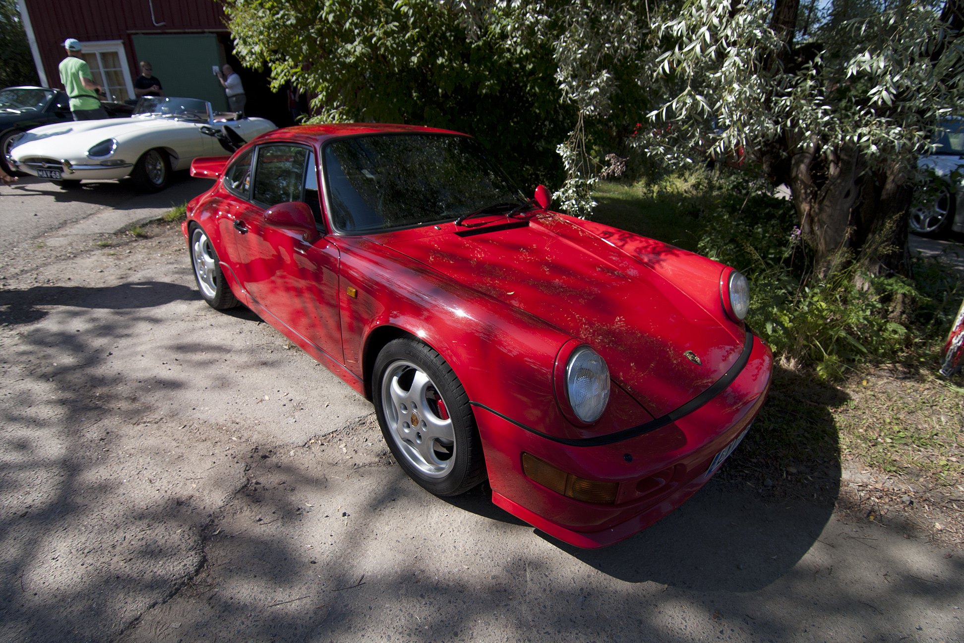 a red sports car sits parked in front of a house