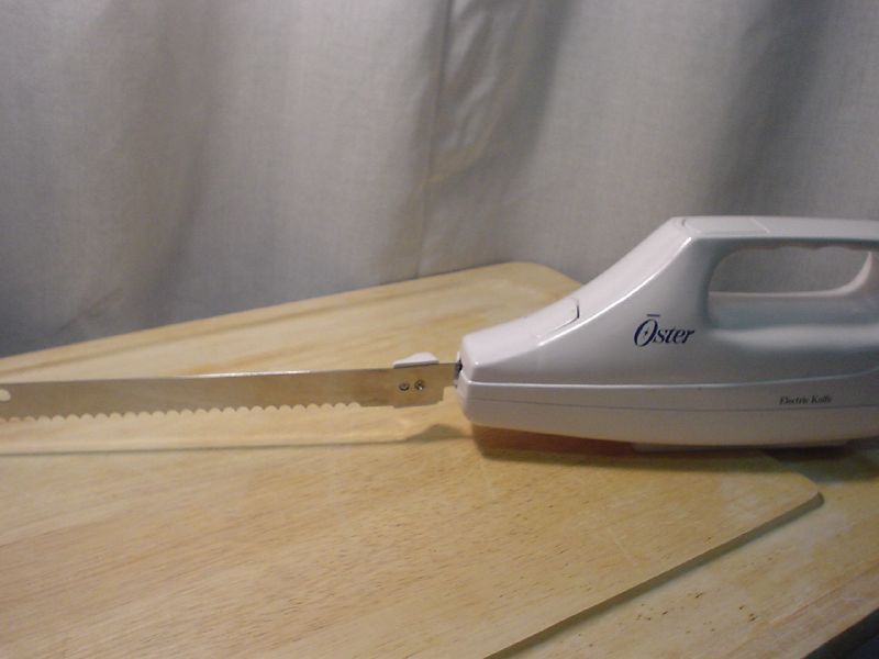 a sharp knife on top of an open white iron