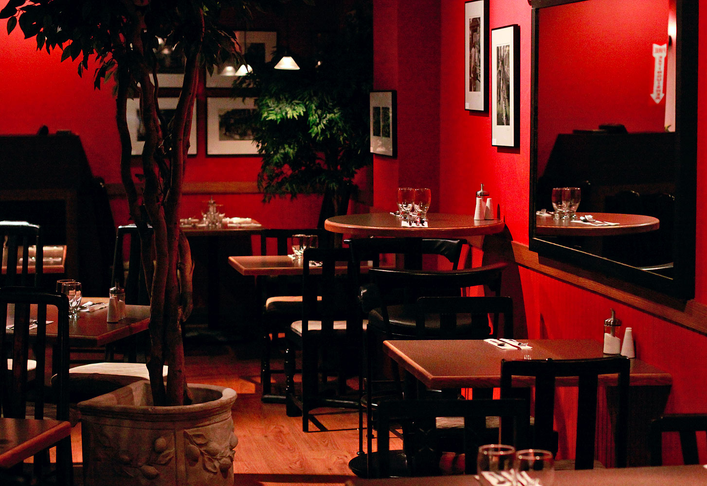 a restaurant with a red wall and tables and chairs