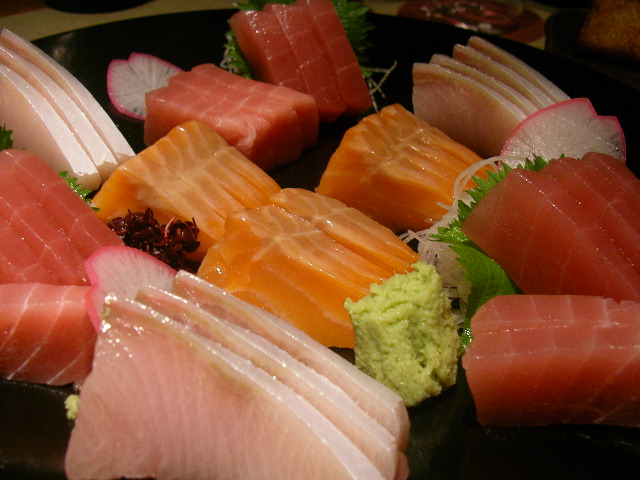 assortment of sushi on display on plate with other items