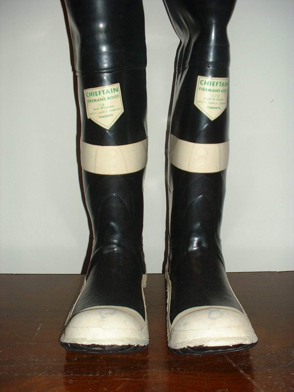 a black and beige pair of rubber boots with black legs