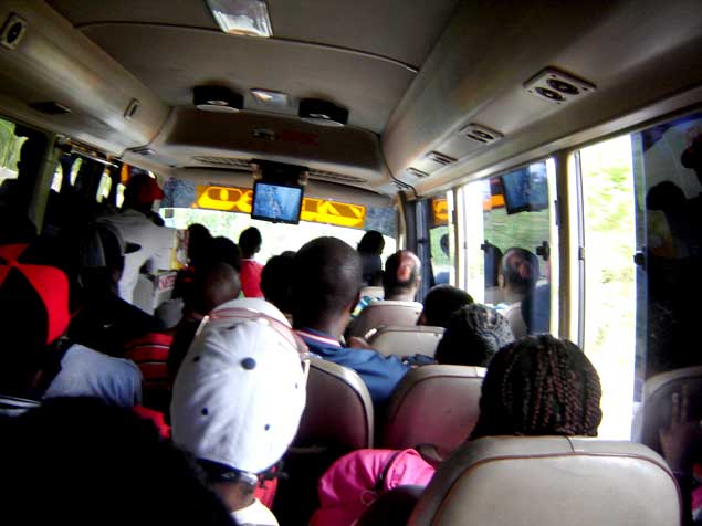 several people are sitting on the bus, some in front and some out