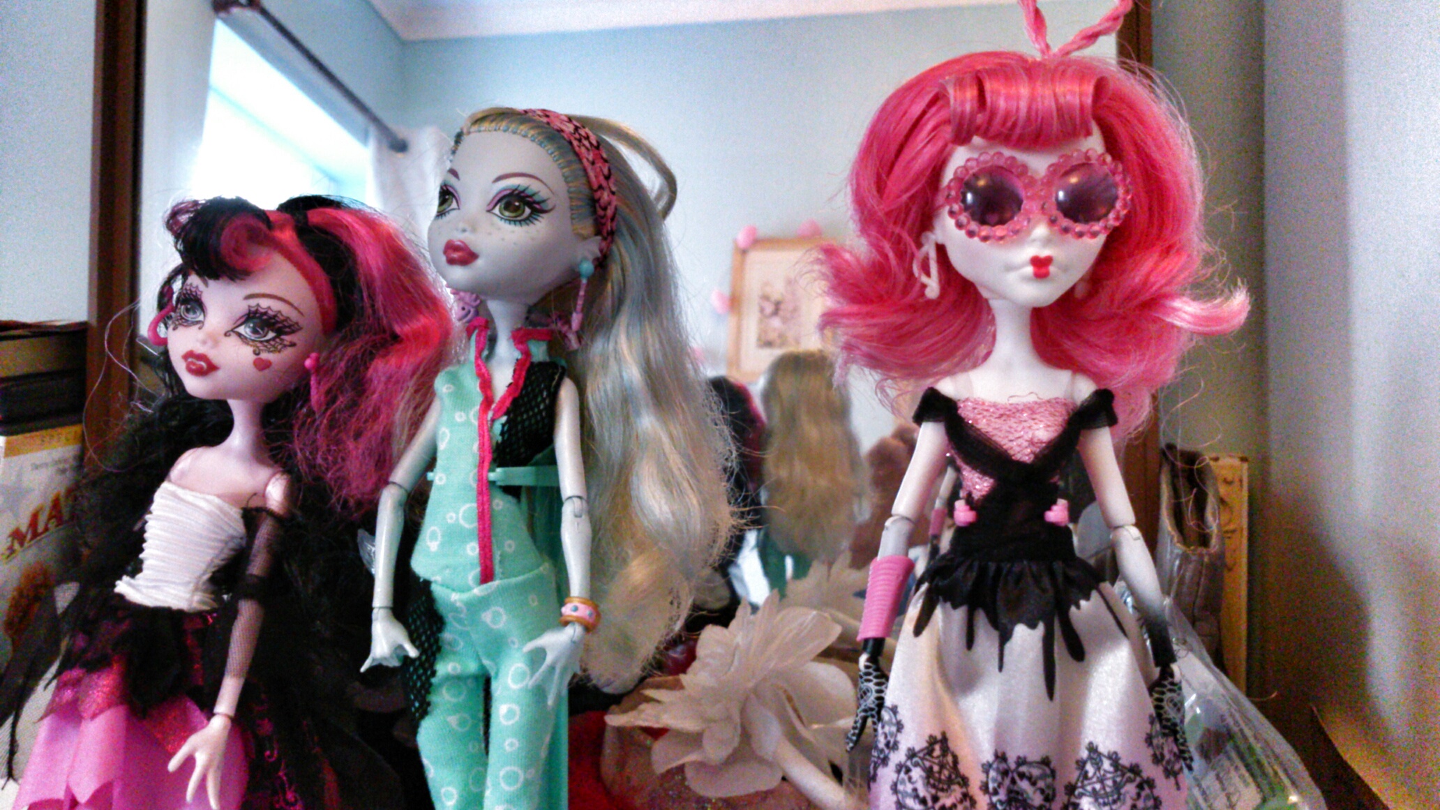 three different fashion dolls lined up in a room