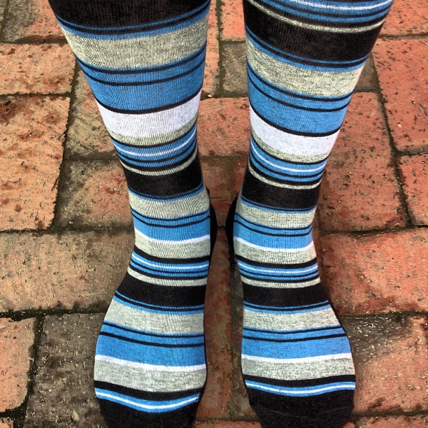 socks are worn very high and have stripes