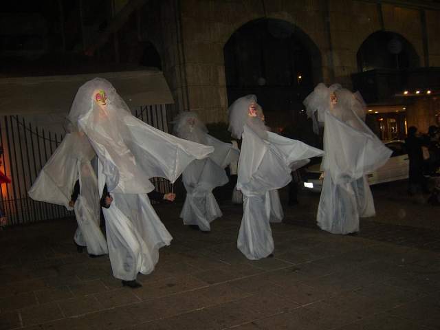 a couple of people in ghost costumes with heads covered in a sheet