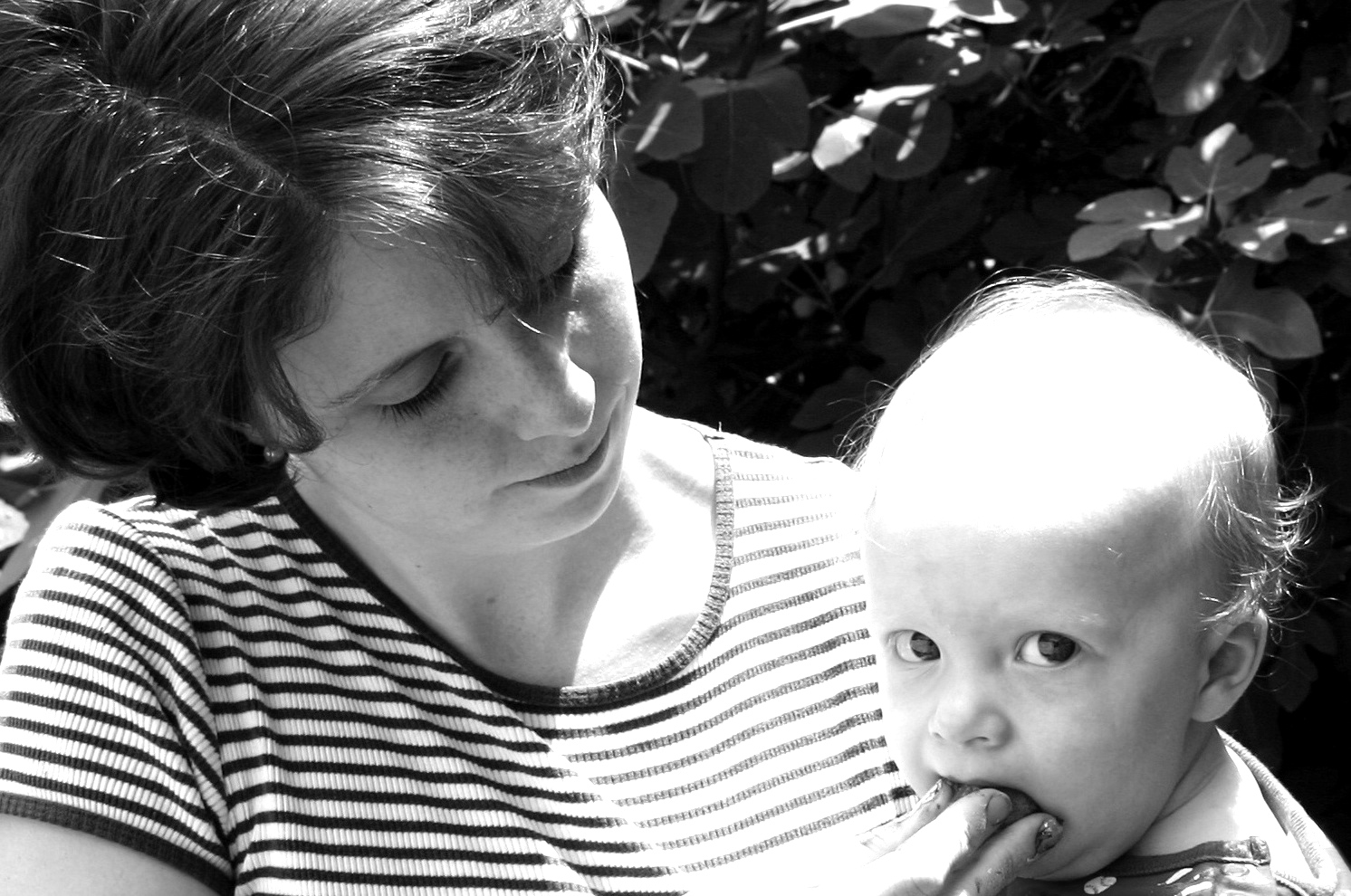 a woman in striped shirt holding a baby