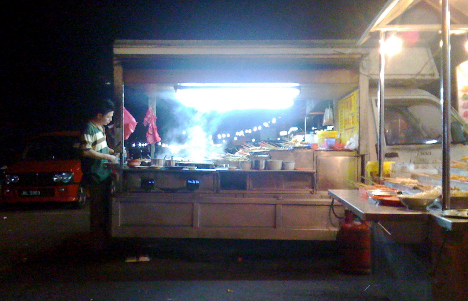 there is a man cooking food in a stand