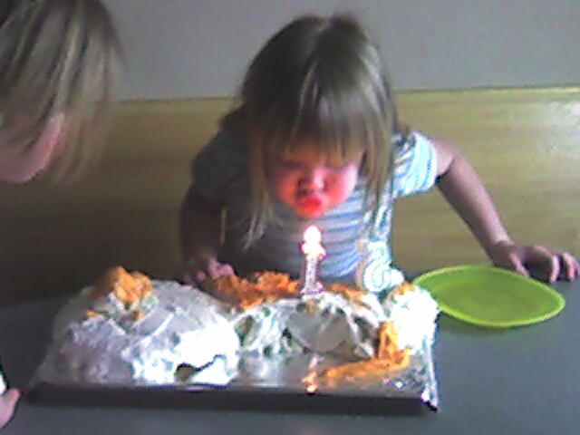 two children blowing out candles on a cake