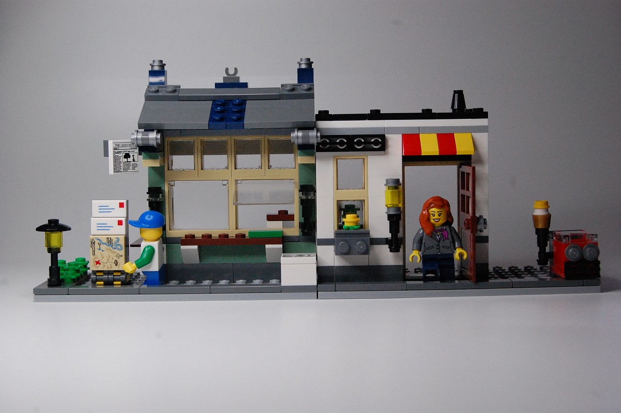 a small model of a firehouse with a woman sitting in the doorway