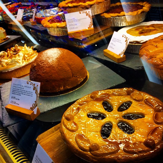 pies and other baked goods sit behind glass
