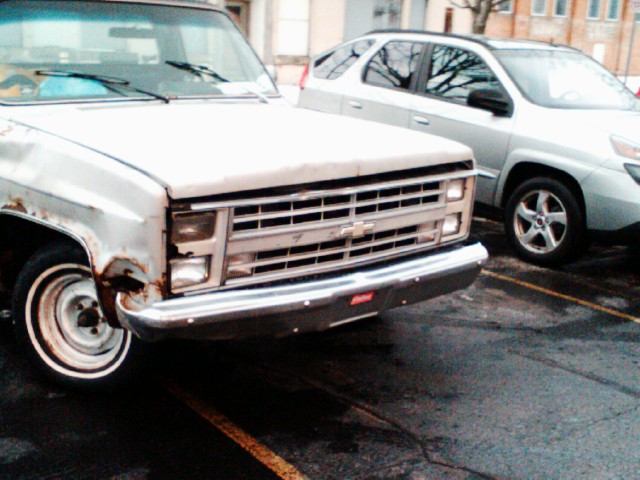 an old white truck is parked in the parking lot