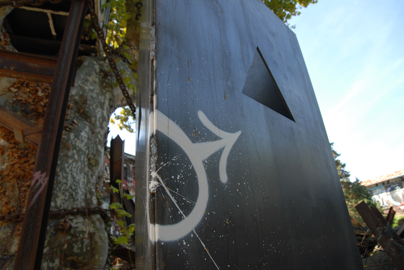 a steel structure with a white circular wheel painted on it