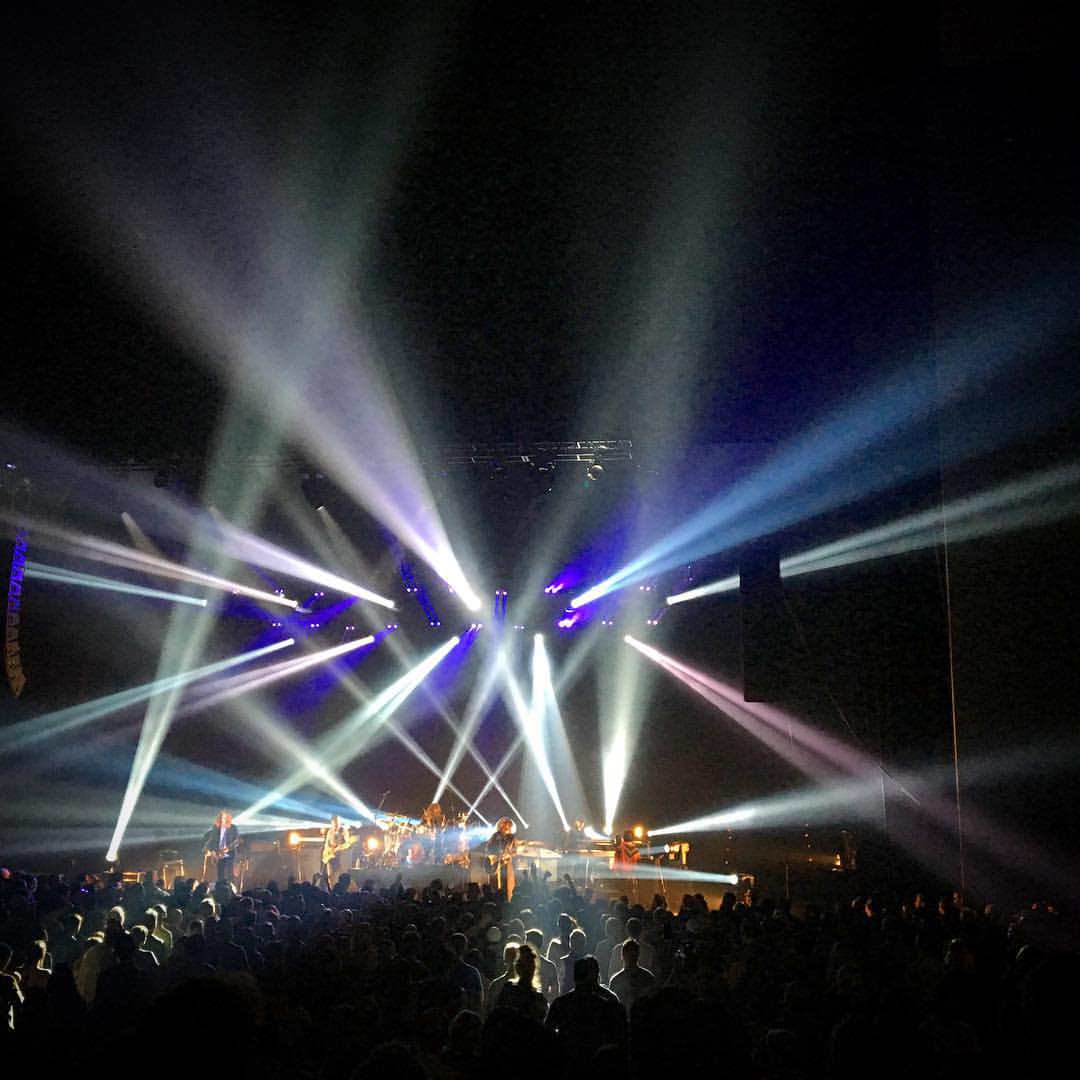 a group of people sitting on top of a stage with lots of lights