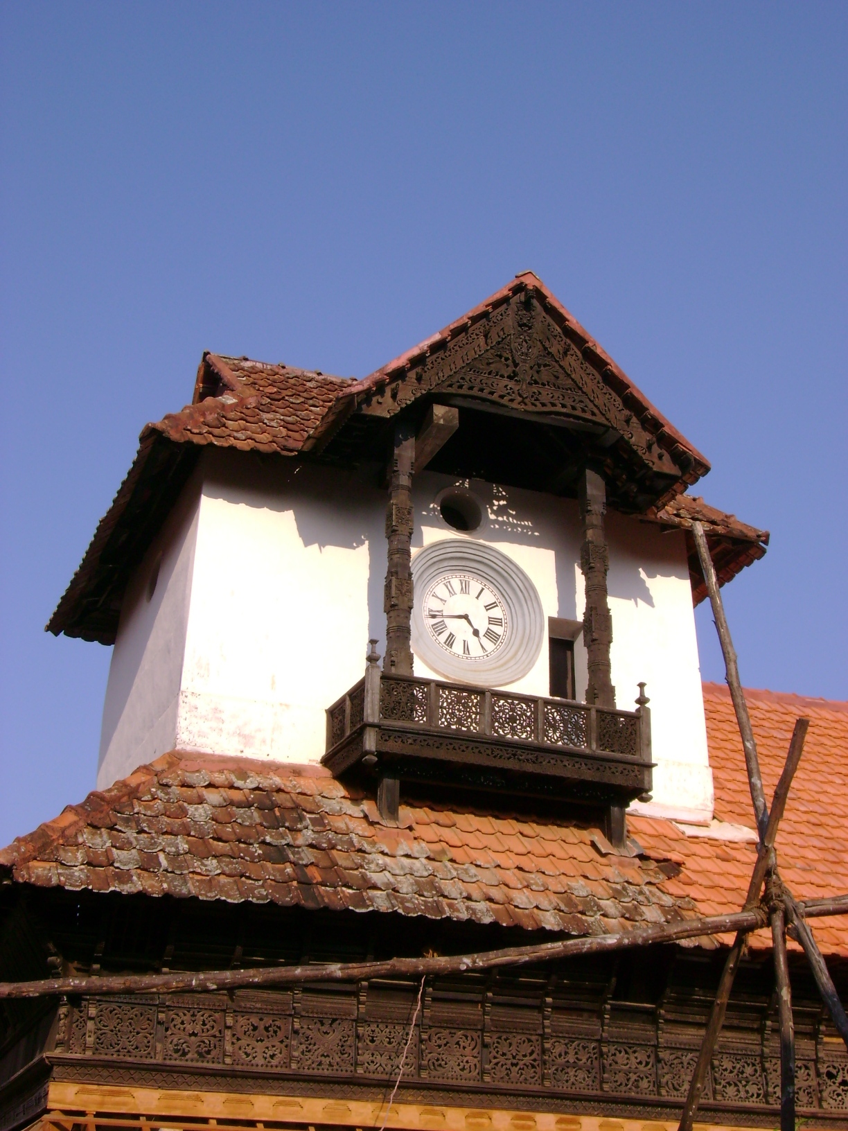 a small building that has a clock attached to the roof