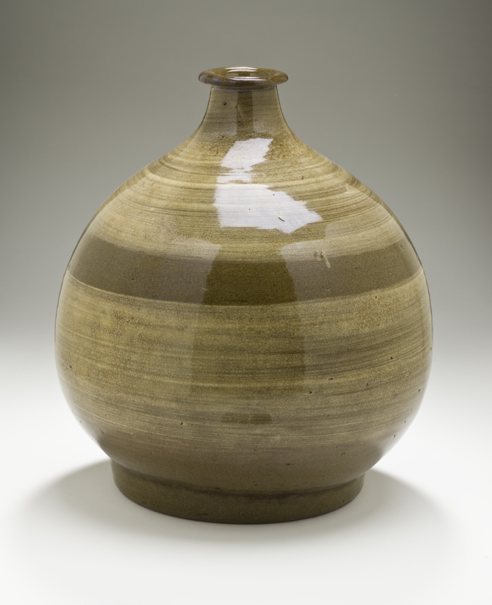 a brown vase on white background with one white spot at the base