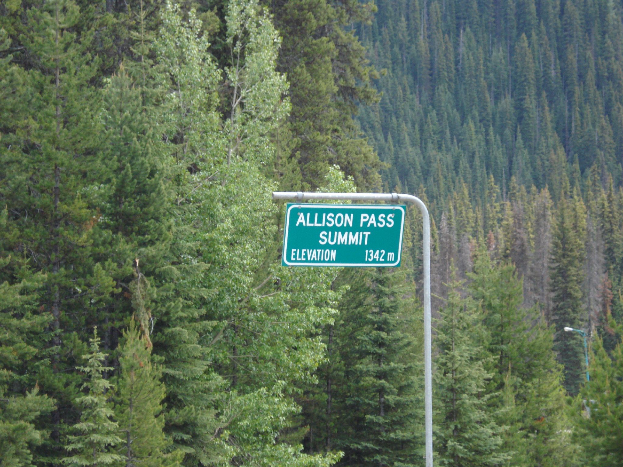 an allis on pass sign hanging off the side of a road