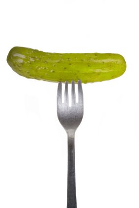 a pickle on a fork with two forks