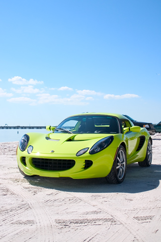 a yellow sports car sits on the beach