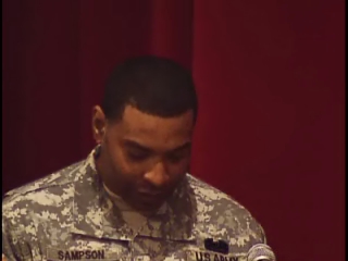 the military man is speaking into a microphone