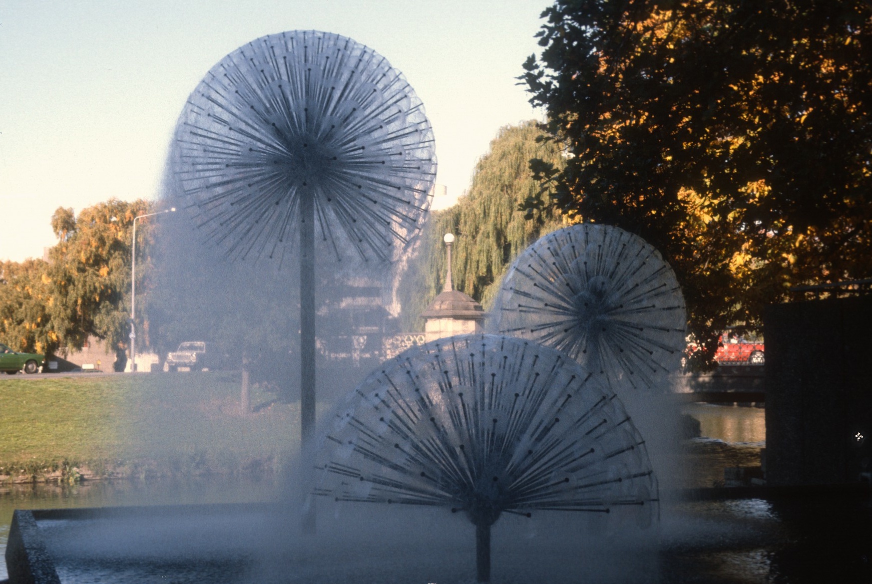 there are two umbrella shaped fountains in the park