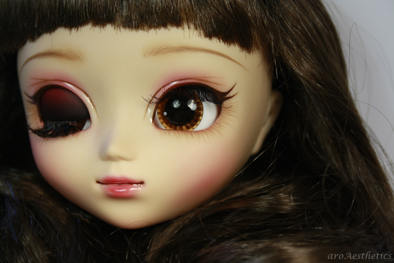 a doll wearing a fake brown eye looking to its left