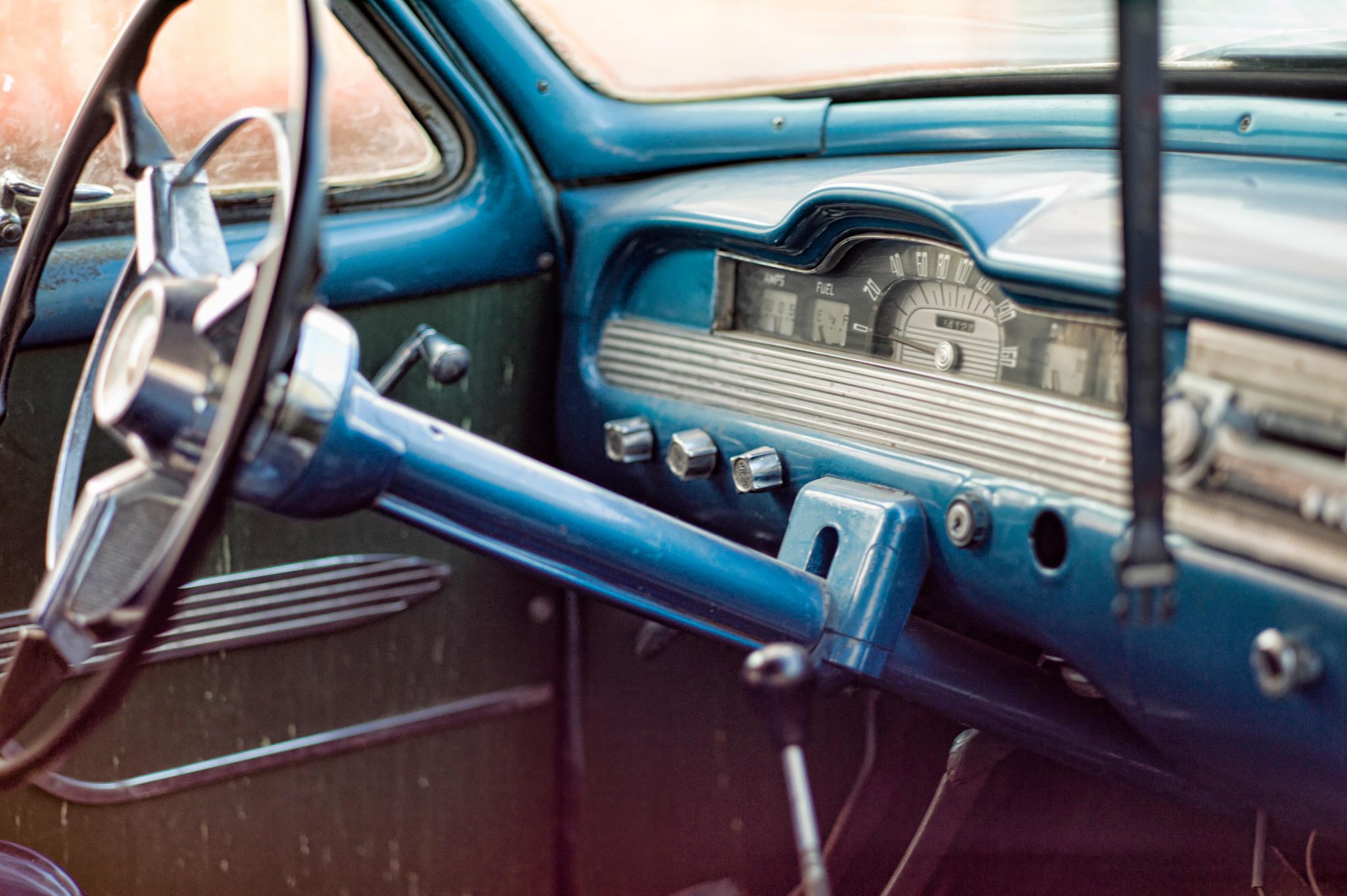 a blue car with an analog clock in the dashboard