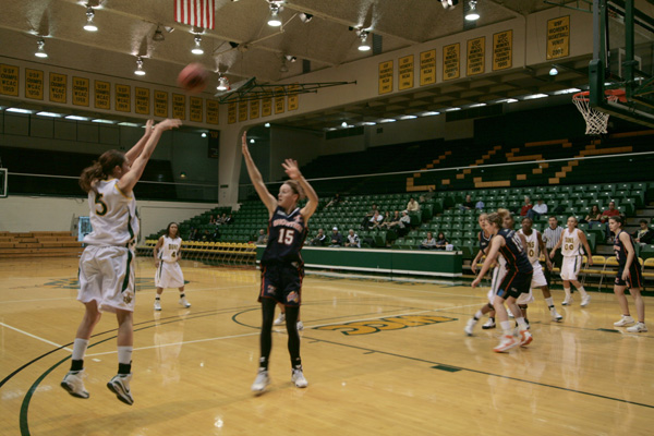 several girls playing basketball in a gymnasium