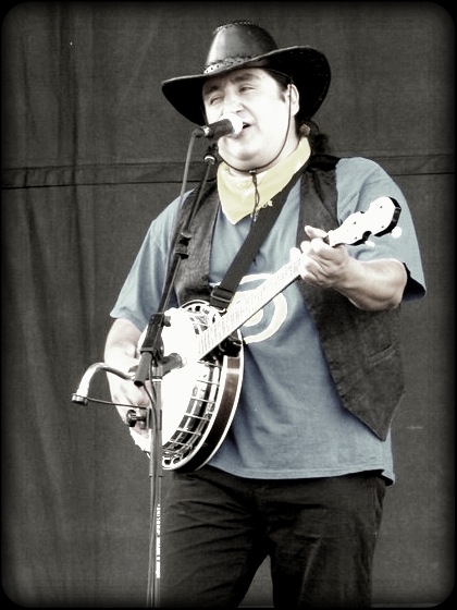 a man playing a guitar while wearing a cowboy hat