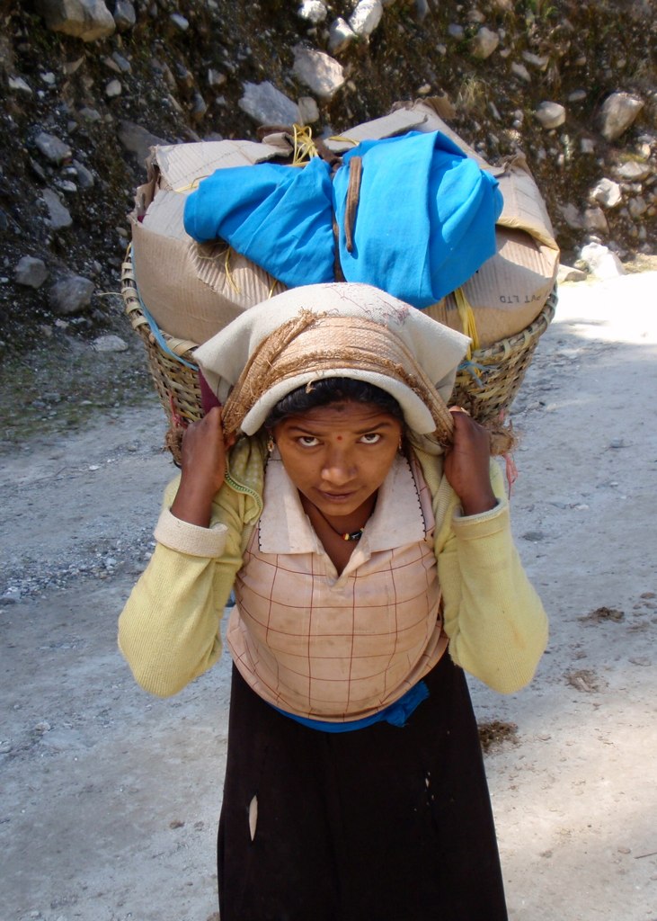 woman carrying two large sacks on her head