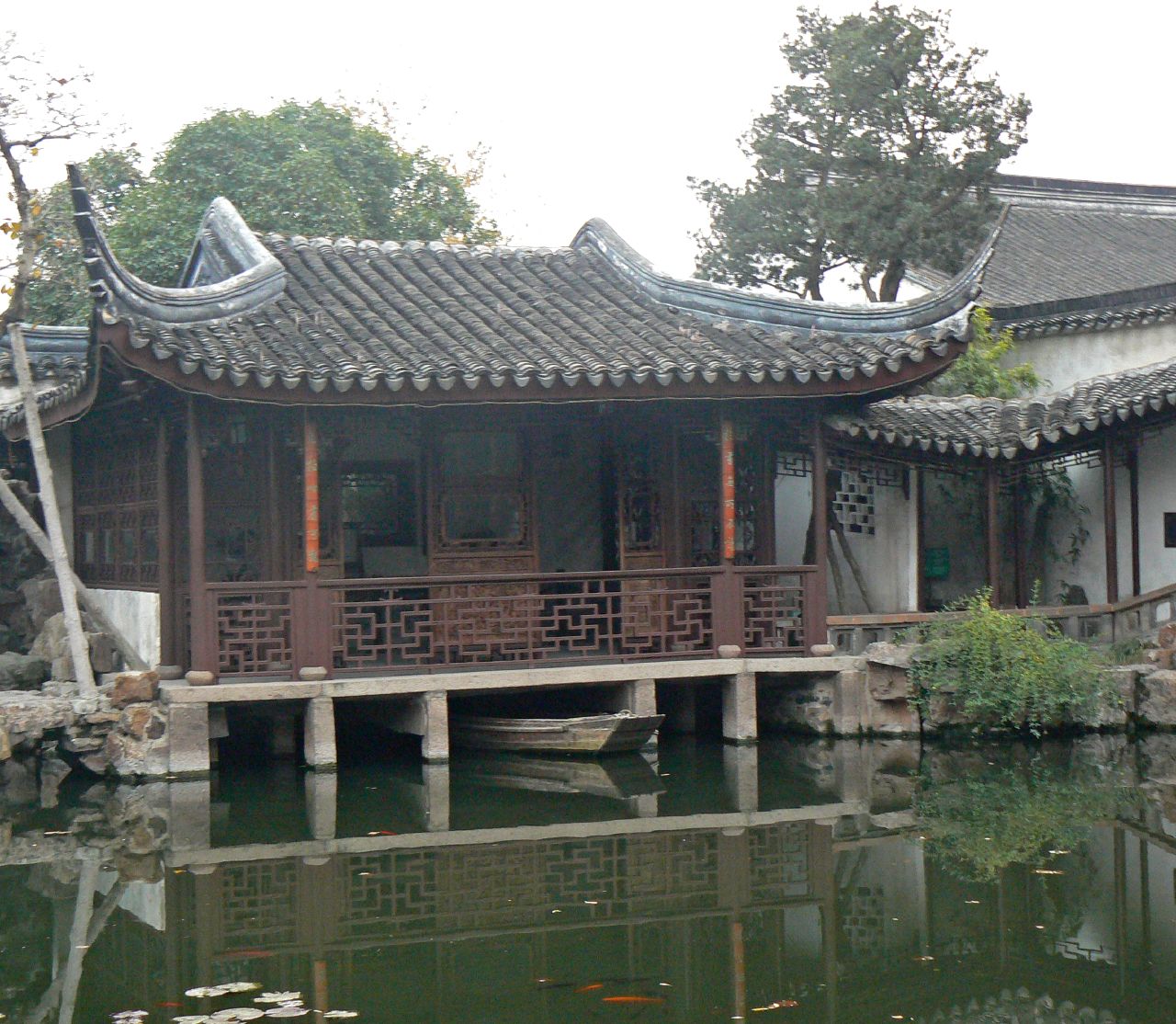an oriental style building stands next to the water