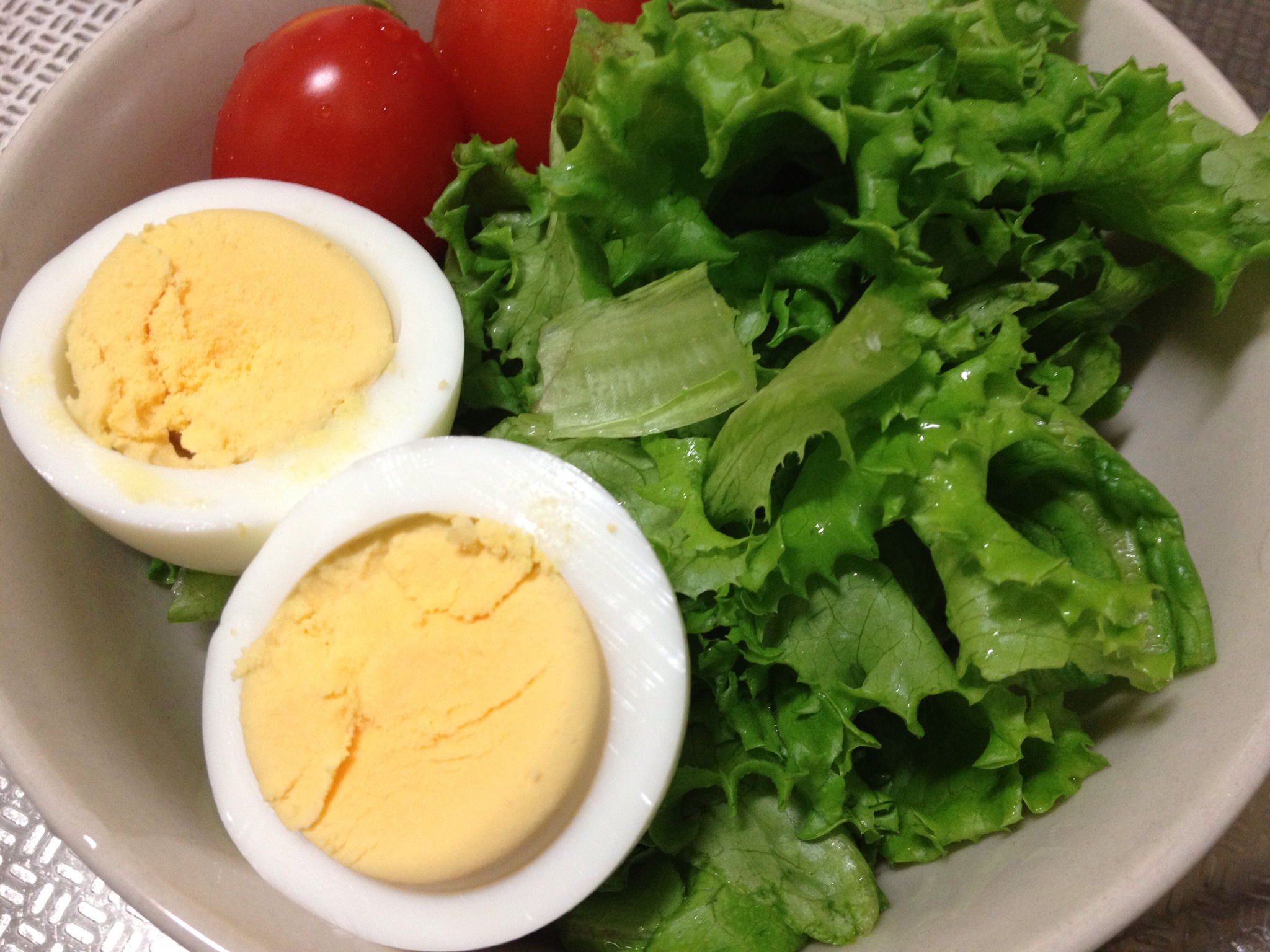 two eggs in an egg shell sit on top of a salad