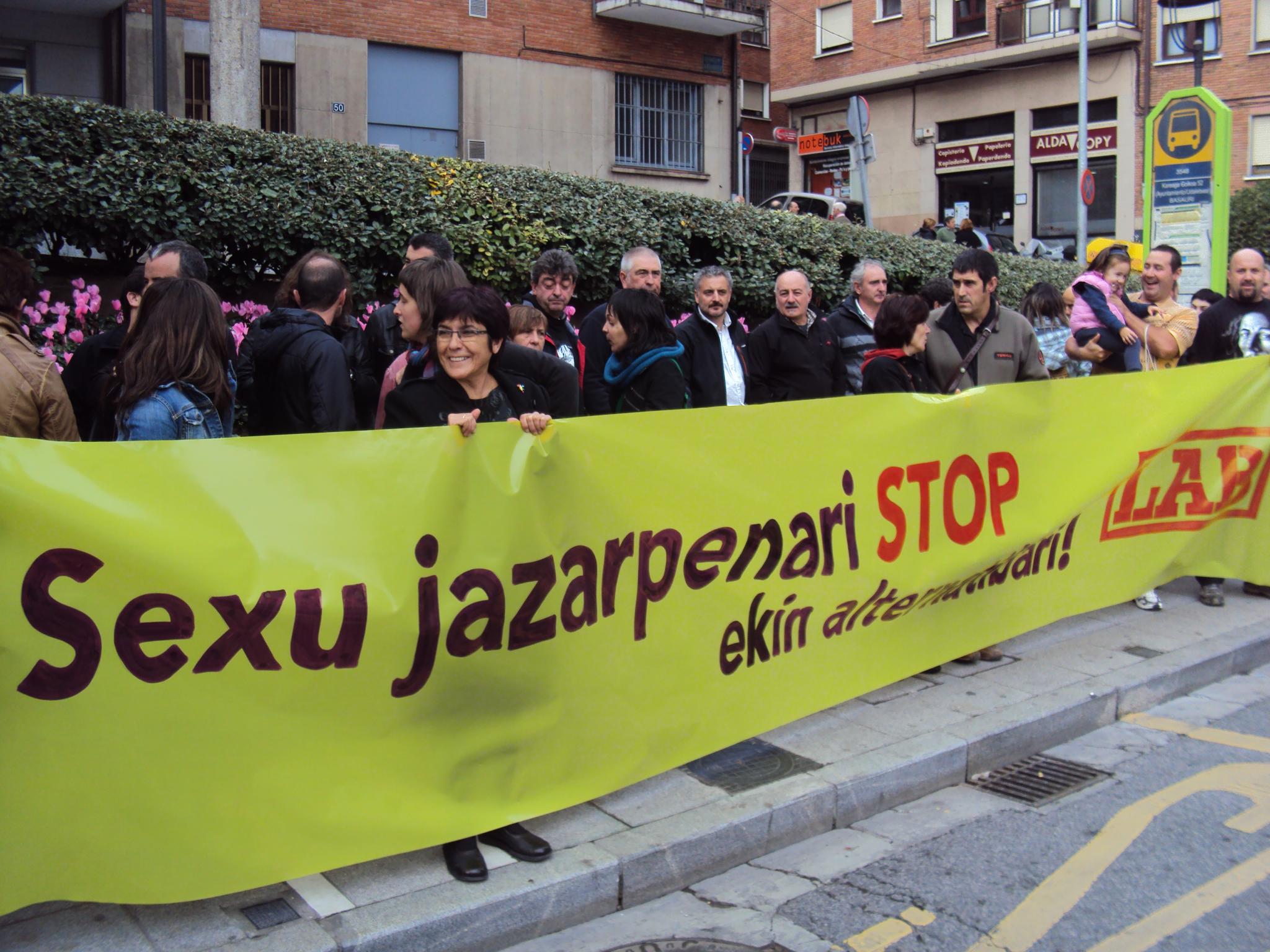 people lined up behind a large yellow banner