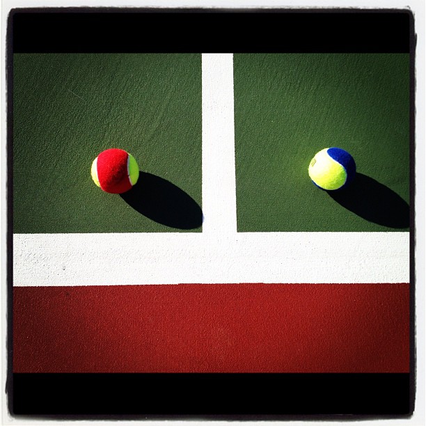 three tennis balls on the side of a green court