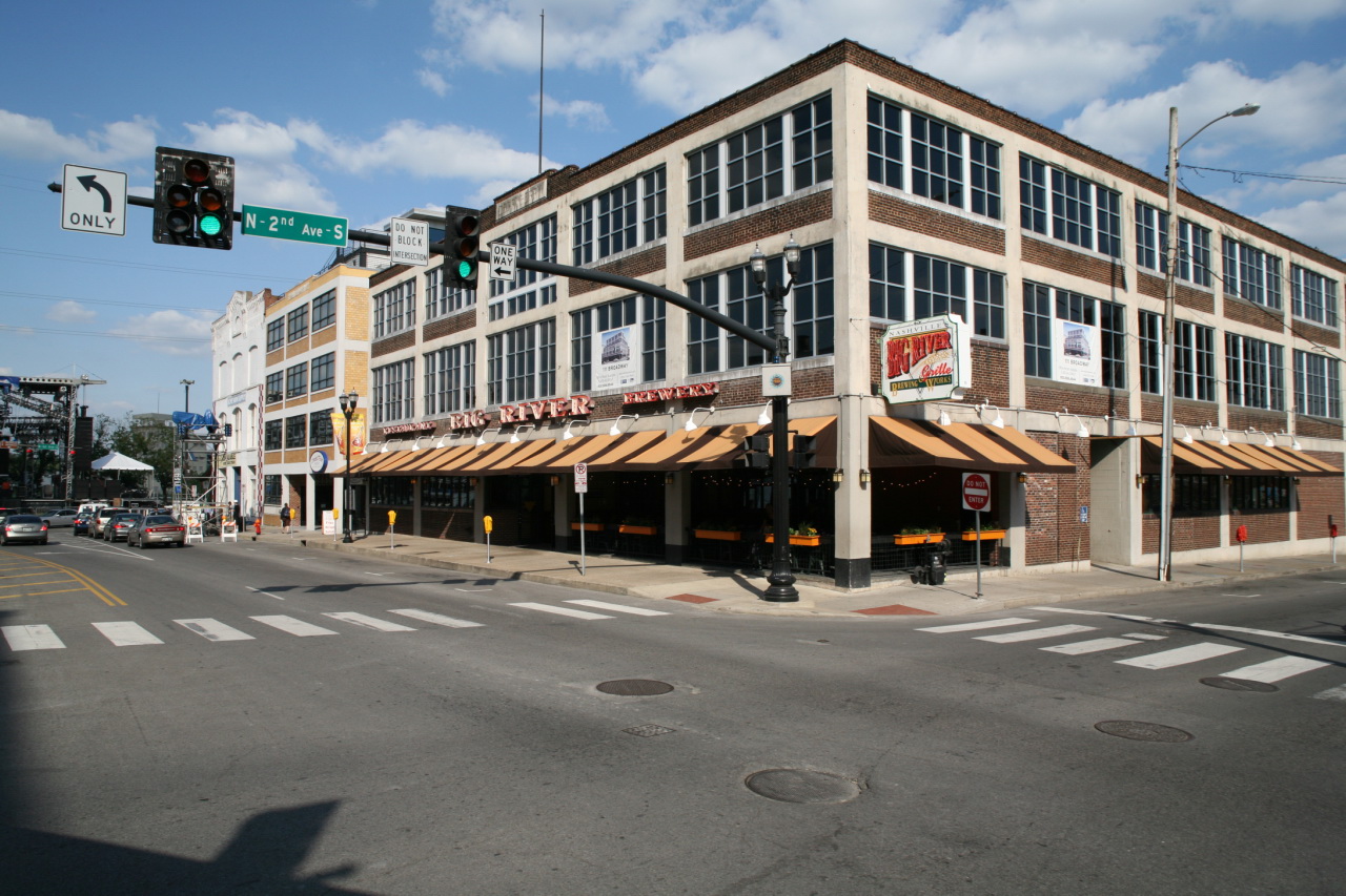 a large brick building at an intersection near a traffic light