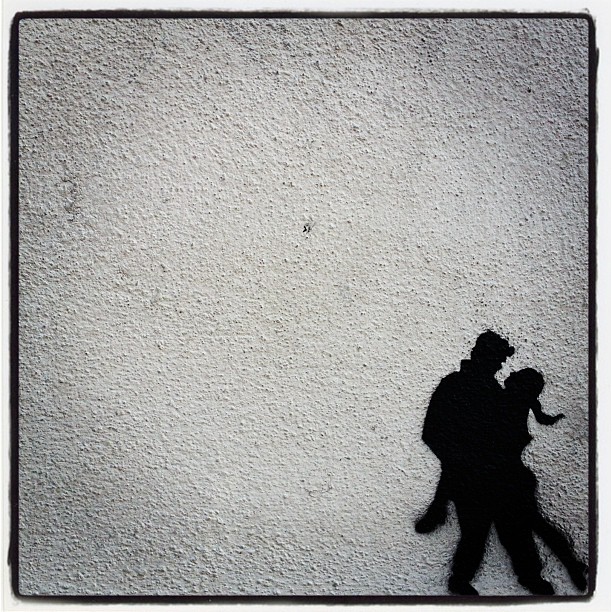 a silhouette of a man carrying a woman against the wall