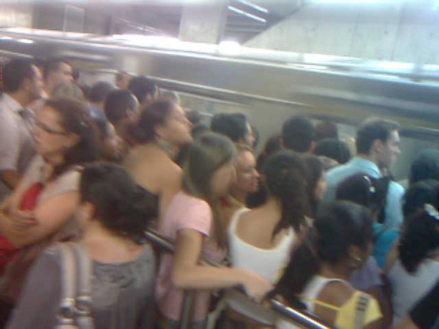 a crowd of people standing on top of a subway