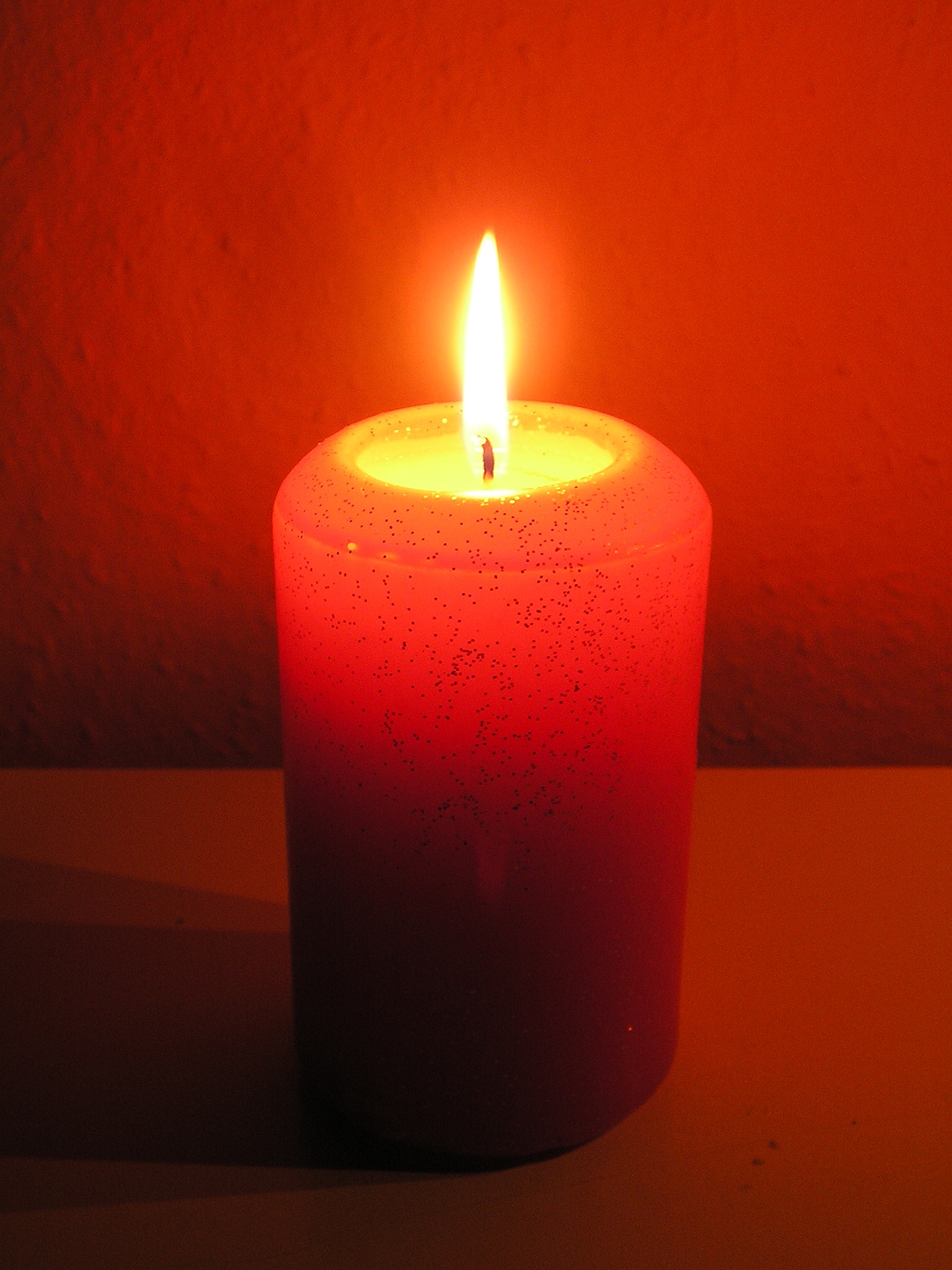 a single candle in the dark on a table