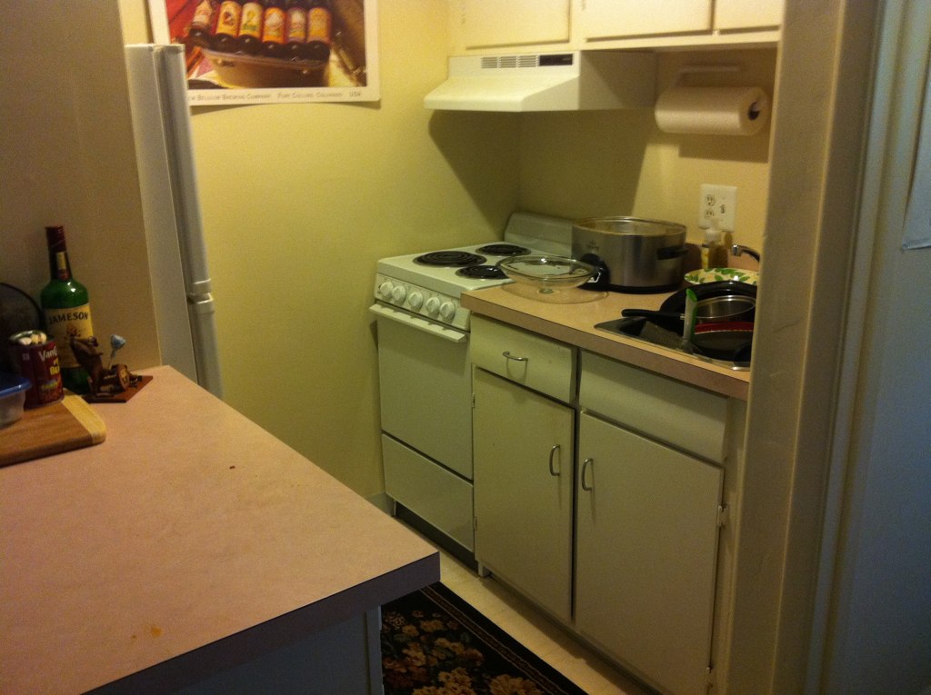 an empty kitchen with a stove and microwave
