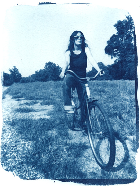woman posing on bicycle riding on grassy field