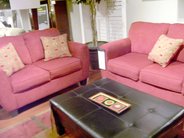 the living room is decorated in pink with gold and pink accents